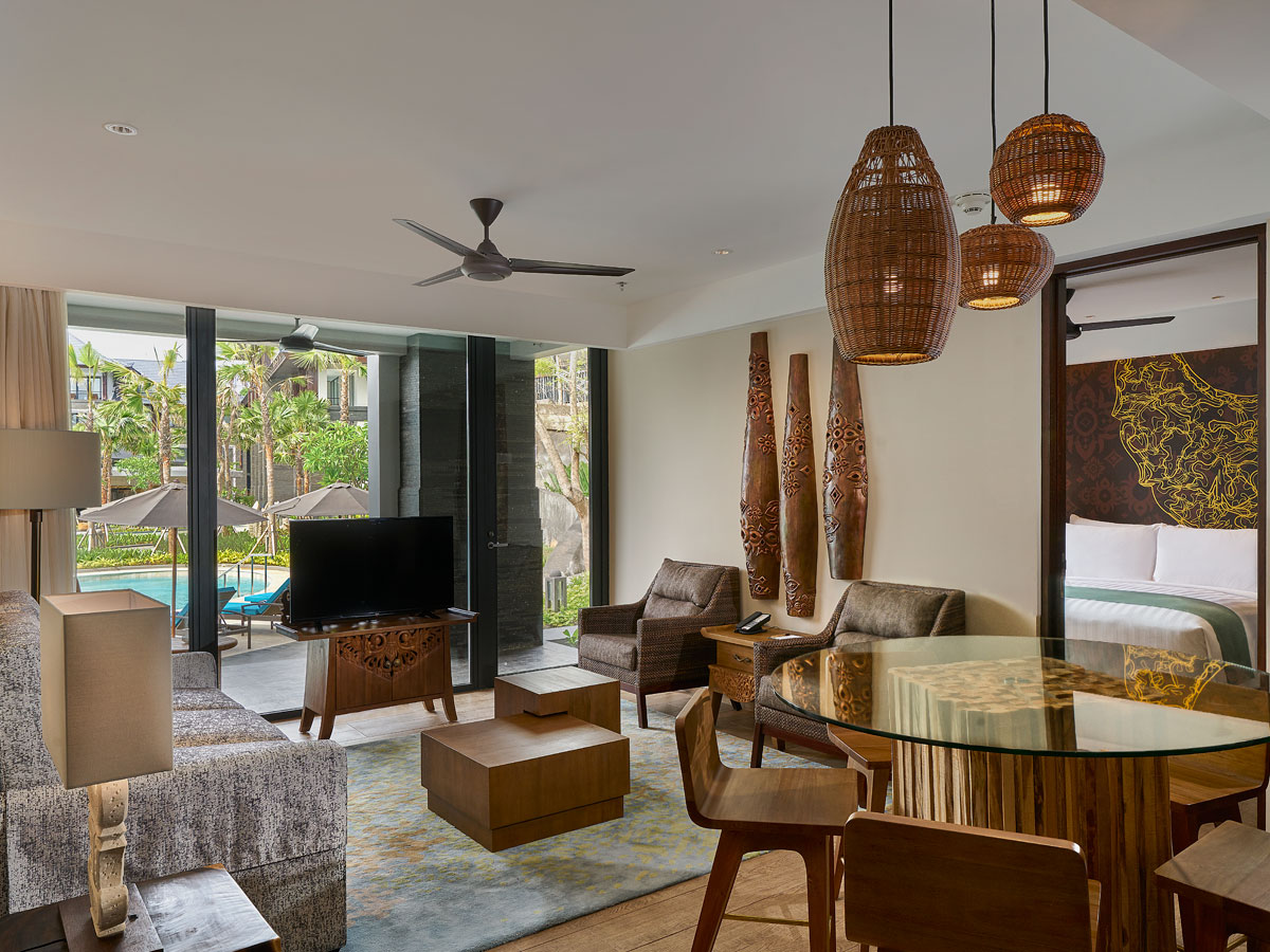 Spacious villa interior with view of tropical resort pool outside window
