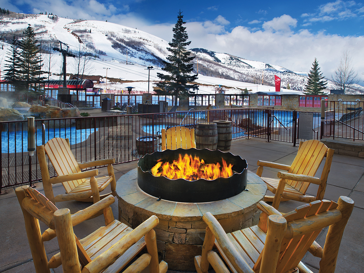 Resort poolside fire pit with snowy mountains in background