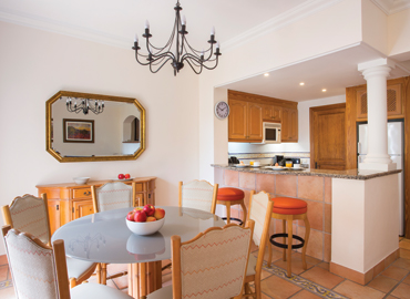 Villa kitchen and dining room with orange barstools and fruit bowl