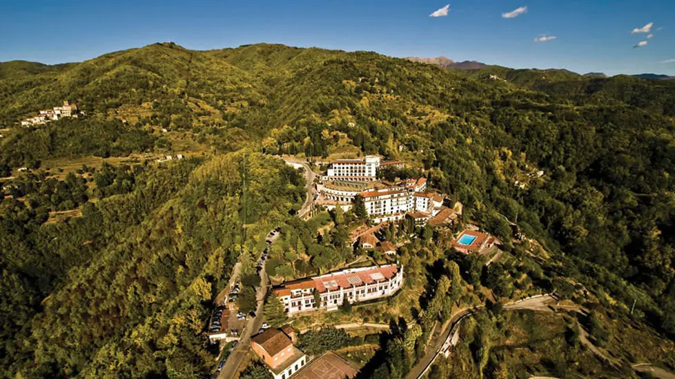 Renaissance Tuscany Il Ciocco Resort & Spa nestled atop a mountain with sprawling multi-level grounds with a pool