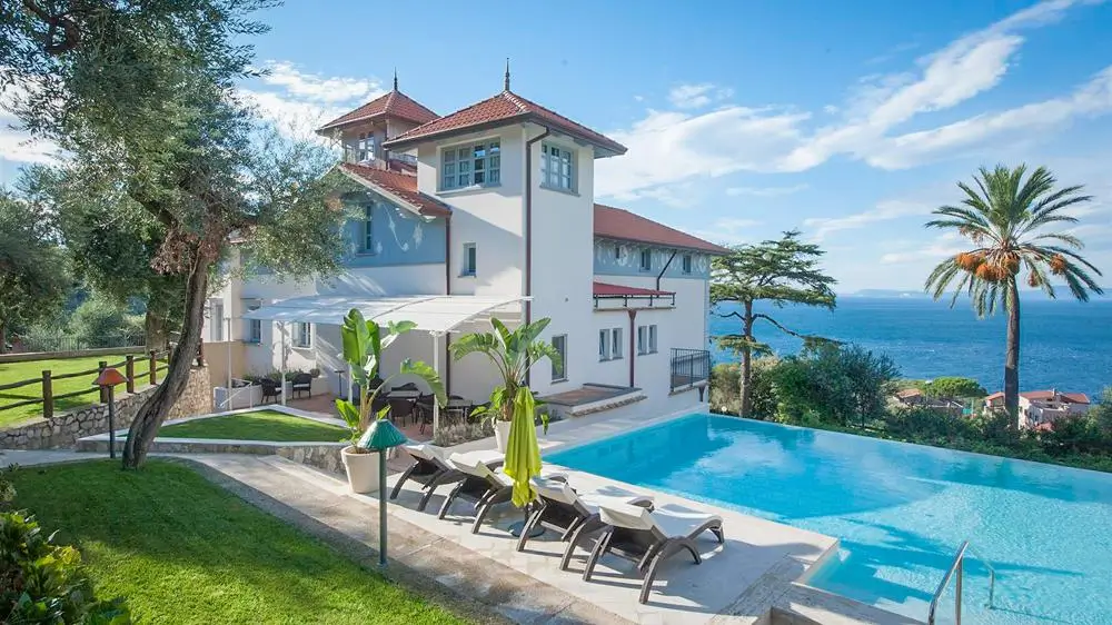 Stradivari, Amalfi Coast resort home on the water with sparkling blue outdoor pool surrounded by palm trees