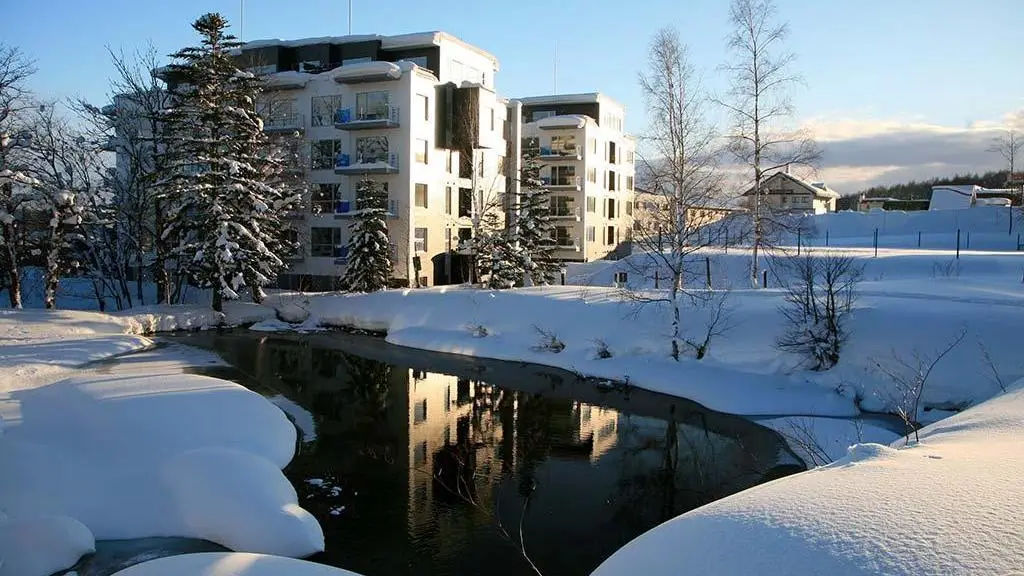 Scenic snowy landscape with a river and modern buildings in Yama Shizen.