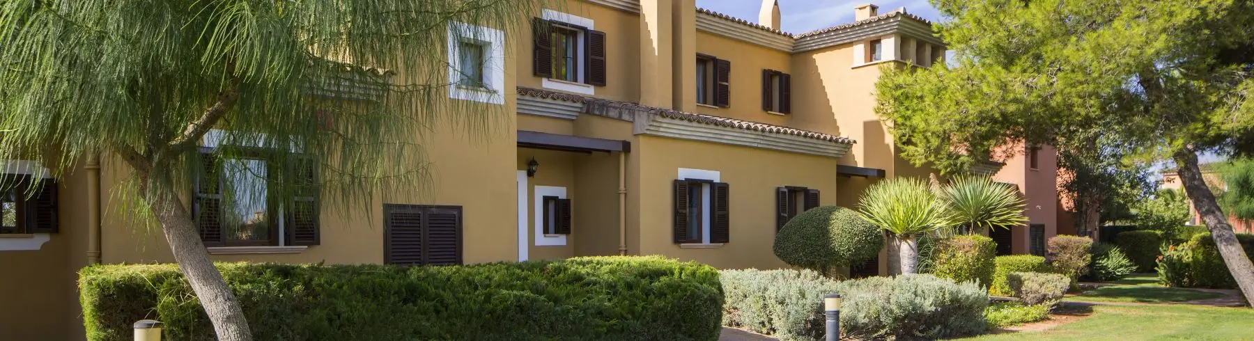 Townhouse exterior with lush gardens at Marriott's Club Son Antem